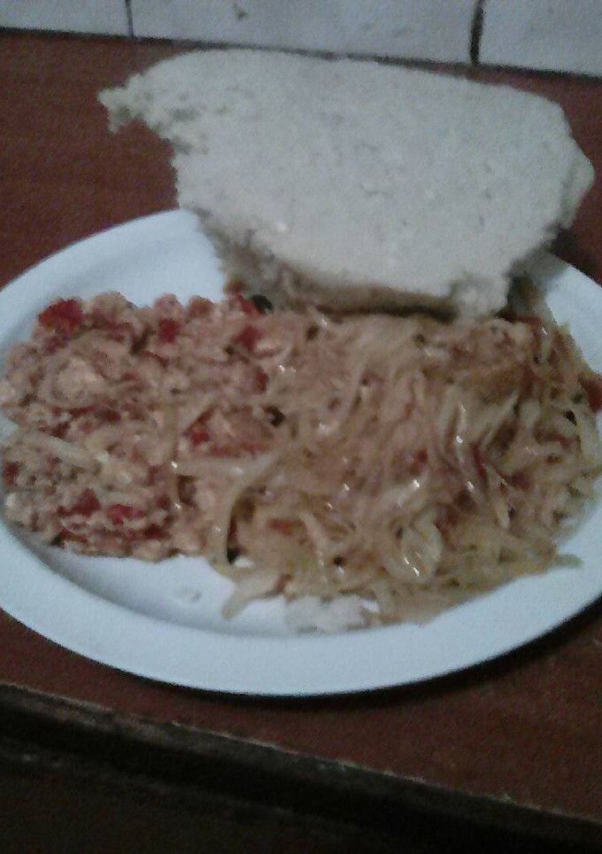 A picture of Fried eggs served with fried cabbage and ugali.