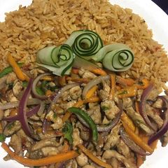 Stir fried chicken with veggies served with jollof rice A picture of Stir fried chicken with veggies served with jollof rice.
