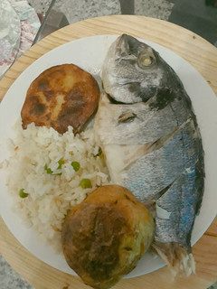Una foto de Dorada al horno empapelado acompañado con papas y arroz