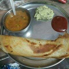 A picture of Sambhar dosa with coconut chtni and sauce.