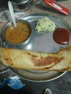 A picture of Sambhar dosa with coconut chtni and sauce.