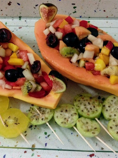 Una foto de Papaya rellena de frutas con piruletas de higos chumbos y kiwis gold