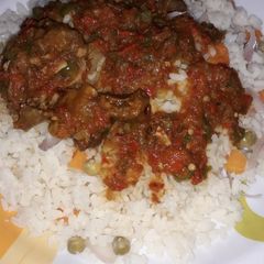 A picture of White rice and source with vegetables.