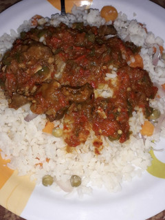A picture of White rice and source with vegetables.