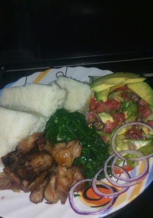 A picture of Goat roasted meat, greens and lettuce kachumbari.
