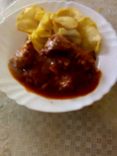 Una foto de Carne con tomate y patatas fritas a rodajas