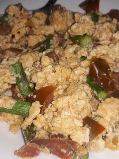 Una foto de Revuelto de huevos con espárragos trigueros, tomate y jamón