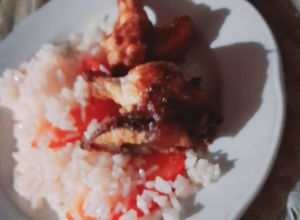 Una foto de Alitas de pollo fritas con arroz y tomate 🍅 🤤