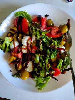 Una foto de Ensalada de tomate con rúcula, aceitunas y mozzarella