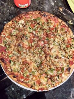 Una foto de Pizza de jamón y queso con verdura y queso gratinado