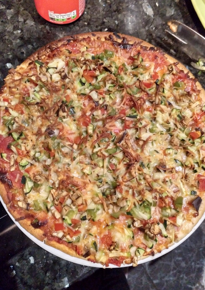 Una foto de Pizza de jamón y queso con verdura y queso gratinado