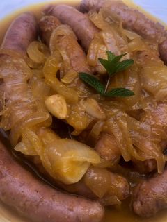 Una foto de Salchichas caseras encebolladas a la naranja 🍊