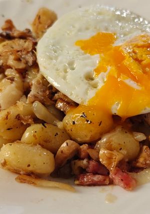Una foto de Ñoquis dorados con champiñones, bacon y huevo
