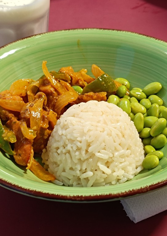 Una foto de Pavo tikka masala con arroz y edamame