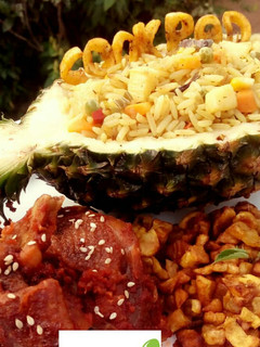 A picture of Pineapple Fried Rice with peppered chicken and fried plantain.