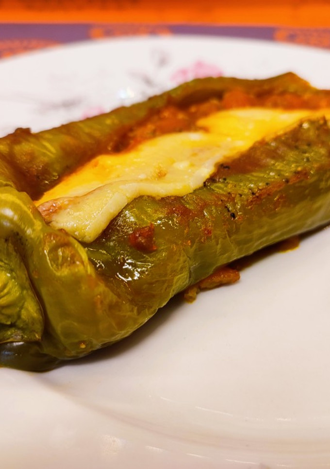 Una foto de Pimiento verde relleno de carne picada, verduras, tomate y queso