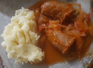 Una foto de Chorizos a la pomarola con puré de papas