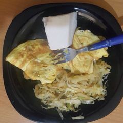 A picture of Ugali served with fried eggs and steamed cabbage.