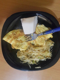 A picture of Ugali served with fried eggs and steamed cabbage.
