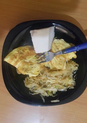 A picture of Ugali served with fried eggs and steamed cabbage.