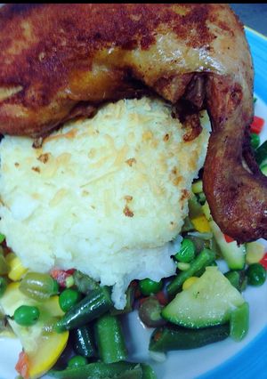 Una foto de Pierna pernil apanada, vegetales al sartén y puré gratinado