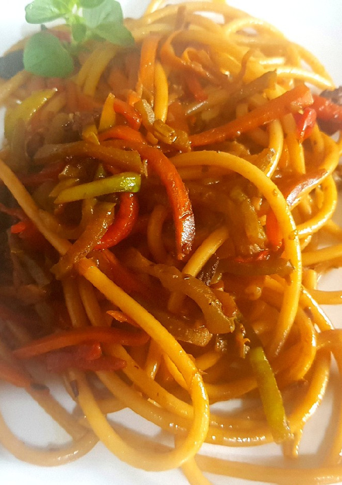 Una foto de Bucattini con hongos y tomates secos, salteado c/vegetales