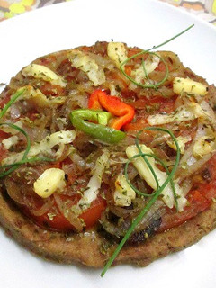 Una foto de Pizza base de atún con tomates y cebolla a la sartén