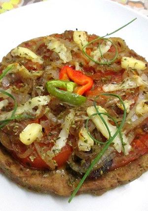 Una foto de Pizza base de atún con tomates y cebolla a la sartén