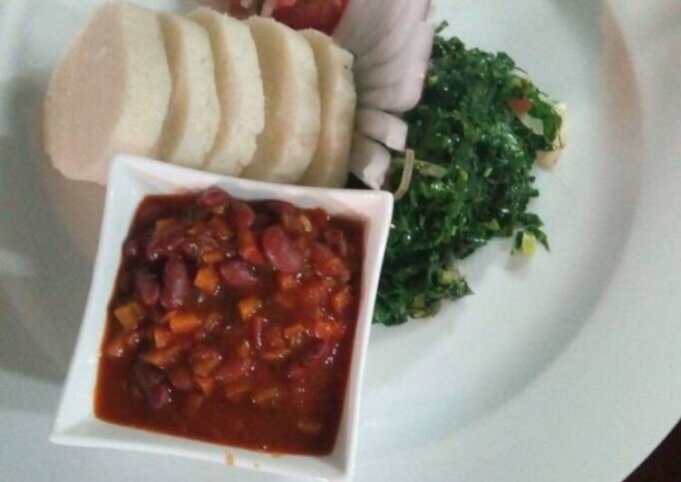 Ugali served with beans stew and vegetables