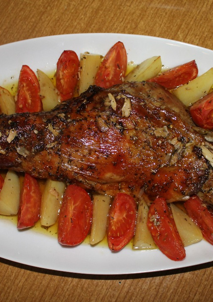 Una foto de Paletilla de cordero al horno con hierbas aromáticas y guarnición de gajos de patata y tomate asados