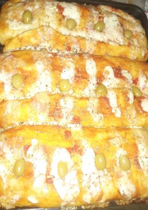 Una foto de Enrollado a la pizza relleno con jamón, queso y tomate