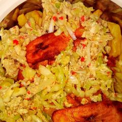 A picture of Egg and cabbage sauce with chips and plantain.