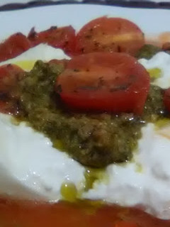 Una foto de Ensalada de burrata sobre tomate rallado con tomatitos salteados y salsa pesto