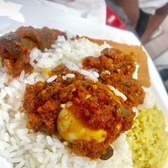 A picture of Rice and pepper sauce with pomo and boiled egg.