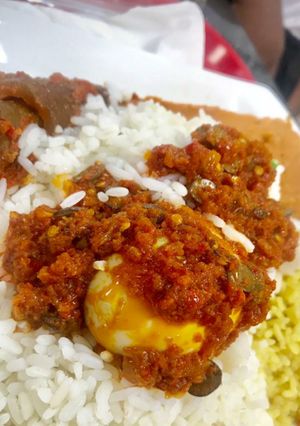 A picture of Rice and pepper sauce with pomo and boiled egg.