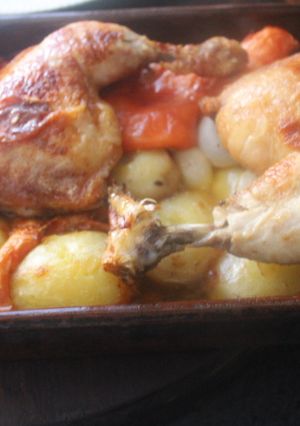 Una foto de Pollo al horno con patatas, tomate, cebolletas y ajo