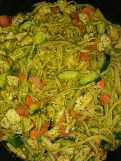 A picture of Chicken vegetables and pesto sauce pasta.