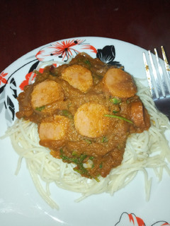 A picture of Spaghetti and sauce with sausages.