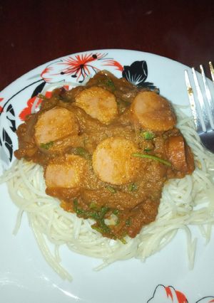A picture of Spaghetti and sauce with sausages.