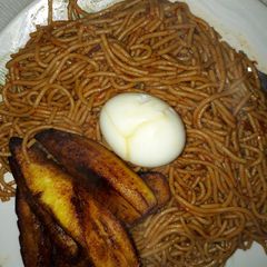 A picture of Spaghetti with fried plantain and egg.
