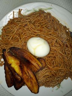 A picture of Spaghetti with fried plantain and egg.