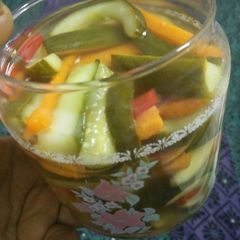 A picture of Pickled cucumber & carrot accompanied with freshgreen & red chillies.