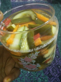 A picture of Pickled cucumber & carrot accompanied with freshgreen & red chillies.