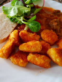 Una foto de Nuggets de pollo con pisto