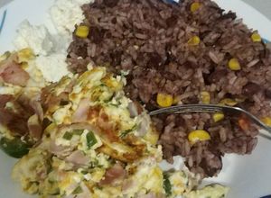 Una foto de Gallo pinto y huevo revuelto con espinacas y jamón