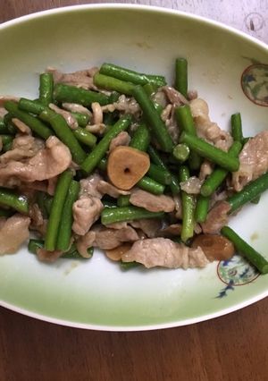 A picture of Fried garlic shoots and pork seasoned with homemade garlic soy sauce.