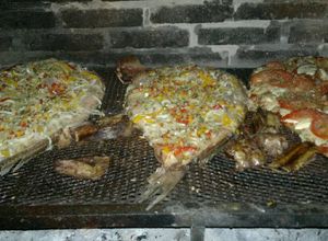 Una foto de Corvinas rubias a la parrilla con verduras y a la napo