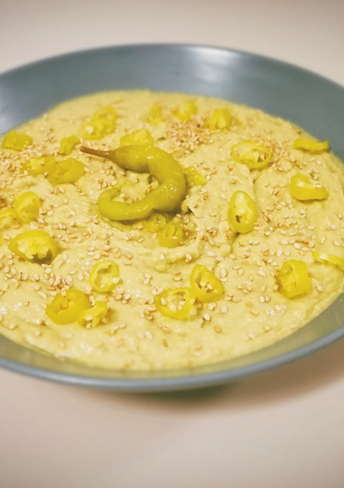 Una foto de Hummus de aguacate con piparras