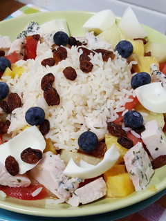 Una foto de Arroz con pollo, huevo duro, tomate, melón y piña