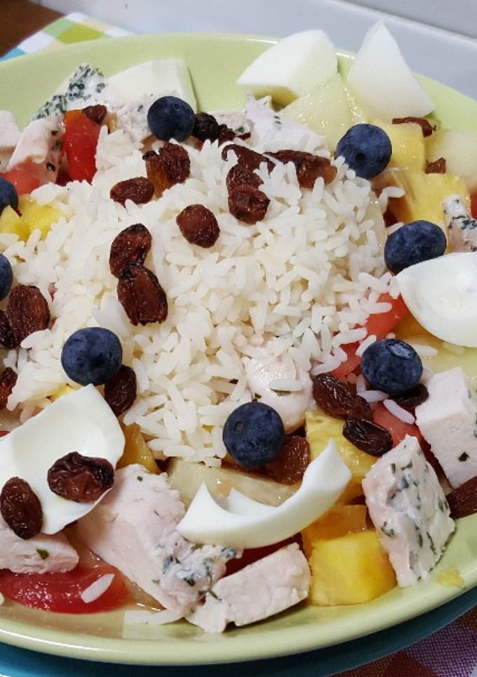 Una foto de Arroz con pollo, huevo duro, tomate, melón y piña